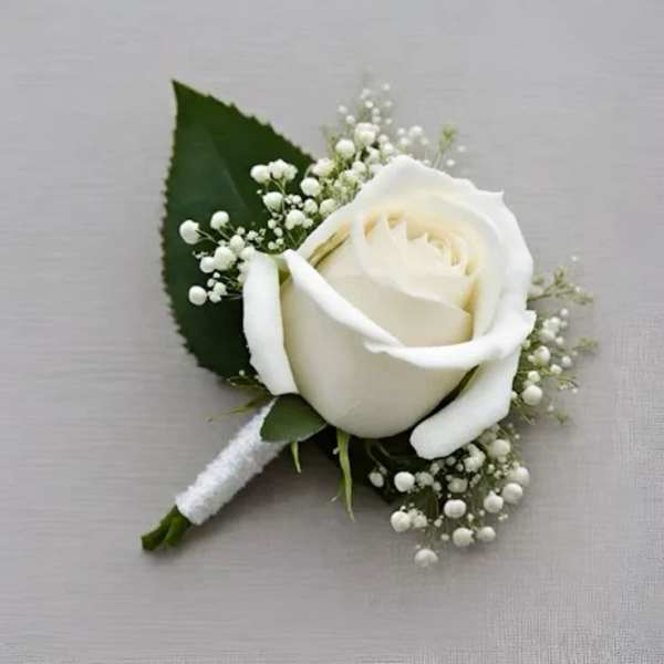 White rose boutonniere with baby's breath and a green leaf