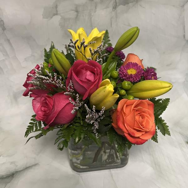 Mixed bouquet of roses and lilies in a glass vase