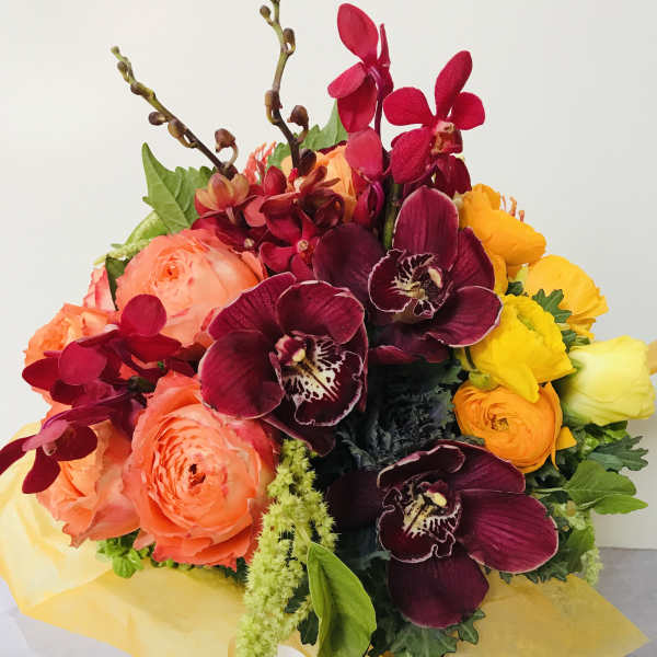Bouquet of coral roses and burgundy orchids with yellow blooms