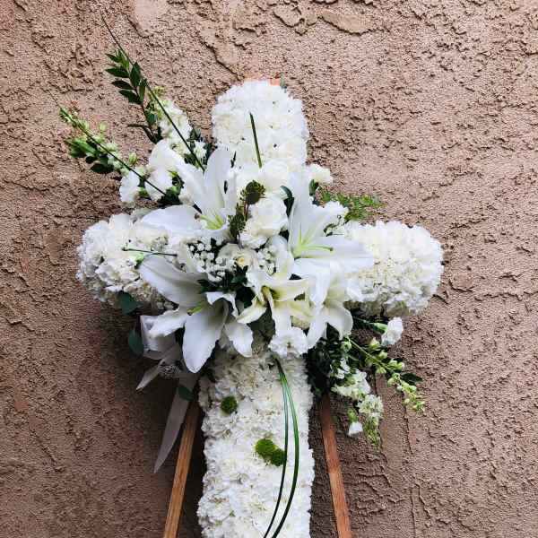 White floral cross on a wooden easel