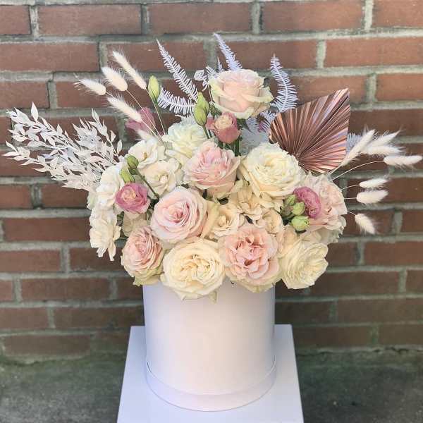 Pastel rose bouquet in a white hatbox with decorative dried accents