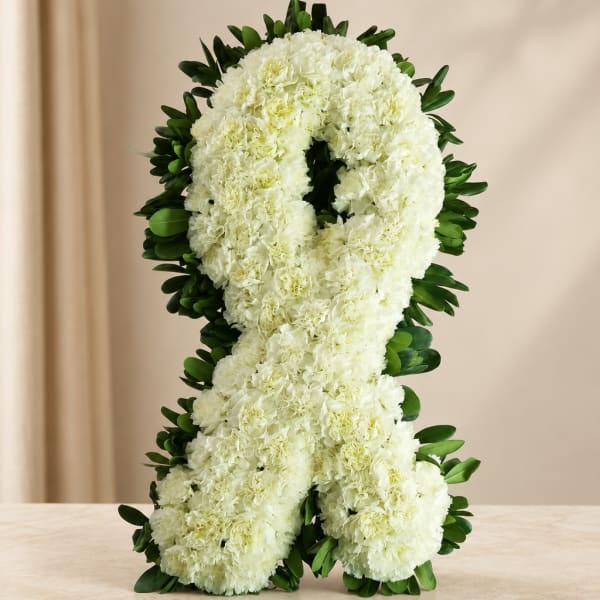 White floral ribbon arrangement with dark green leaves