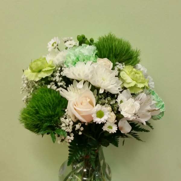Bouquet of white and green flowers in a clear glass vase