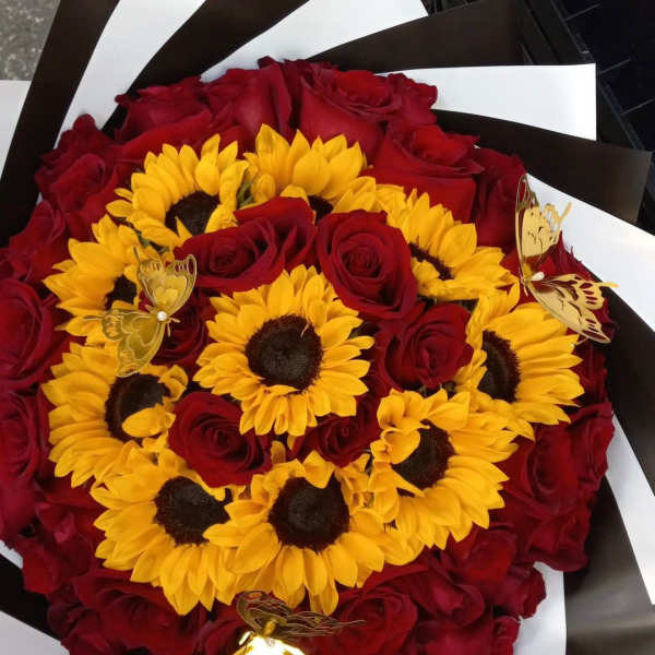 Bouquet of red roses and yellow sunflowers with butterfly picks