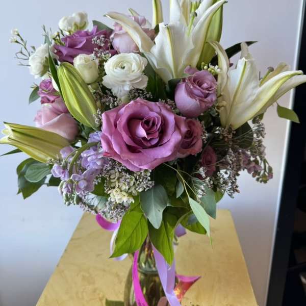 Bouquet of pink roses and white lilies in a glass vase