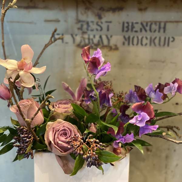 Pink roses and purple sweet peas in a white vase