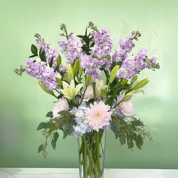 Lavender and white floral arrangement in a clear glass vase