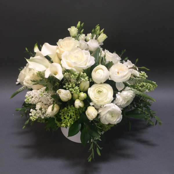 White floral arrangement in a low round container