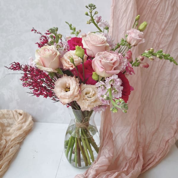 Pink and cream rose bouquet in a clear glass vase