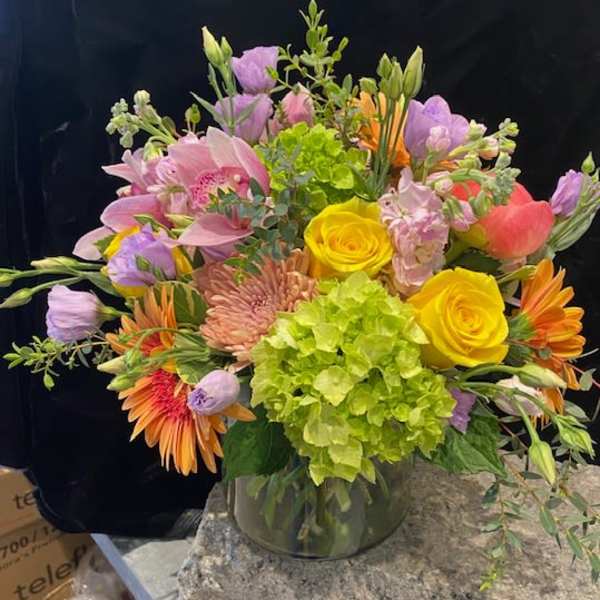 Mixed bouquet in a glass vase with yellow roses and pink lilies