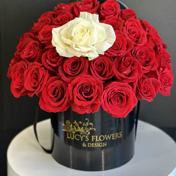 Red and white roses arranged in a black hatbox