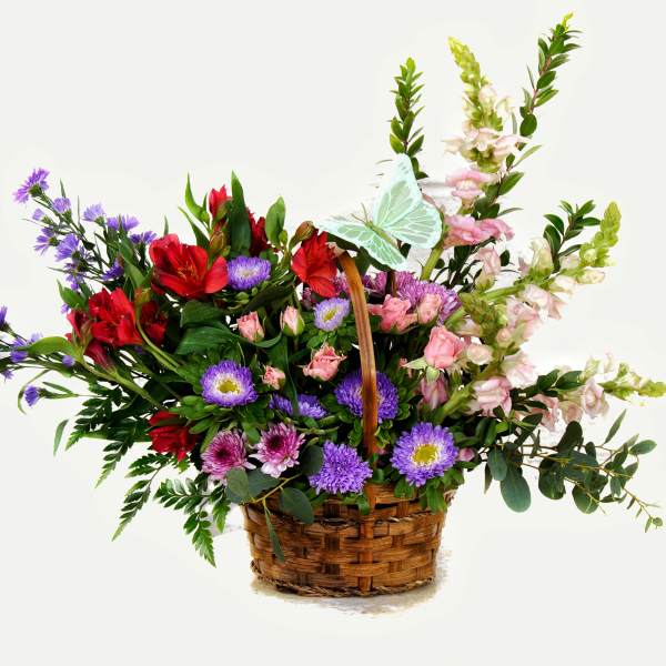 Basket arrangement of red, pink, and purple flowers with tall blooms