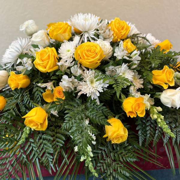 Yellow and white roses with white daisies in a lush floral spray
