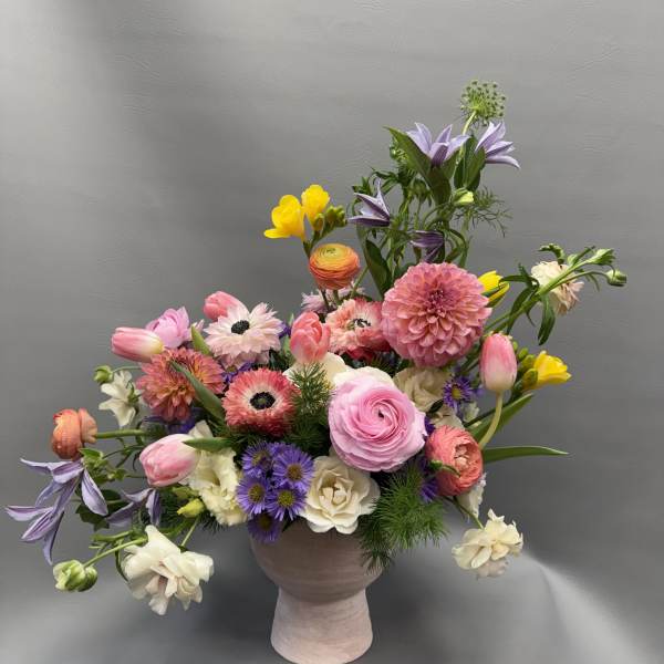 Mixed bouquet in a pink vase with pink, purple, white, and yellow flowers