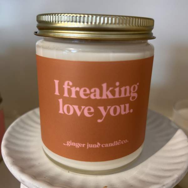 Orange-labeled candle in a glass jar with a gold lid