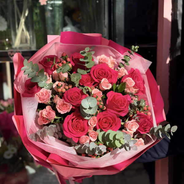 Bouquet of hot pink and blush roses wrapped in pink paper