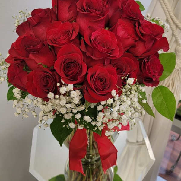 Bouquet of red roses with white baby's breath in a glass vase