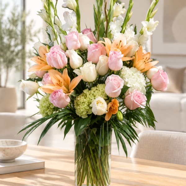 Pink roses and orange lilies in a clear glass vase