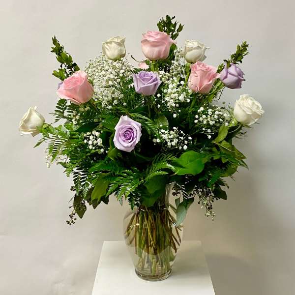 Bouquet of pink, white, and lavender roses in a clear glass vase