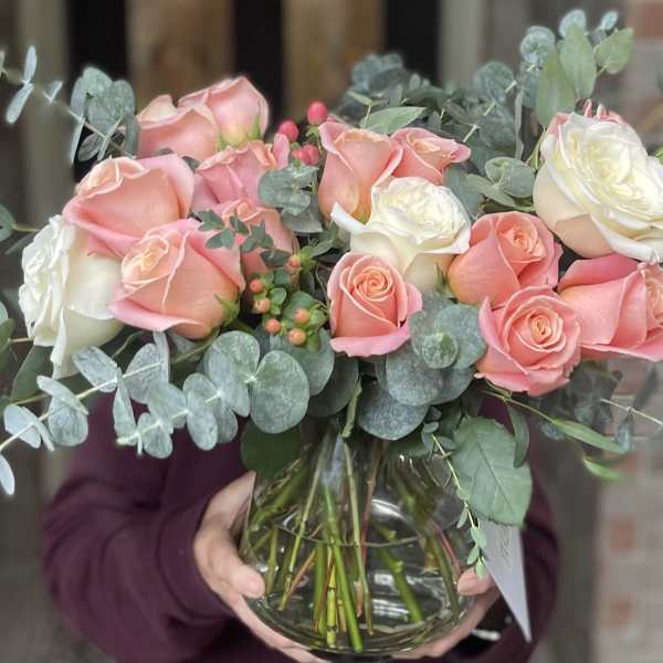 Bouquet of pink and white roses in a clear glass vase