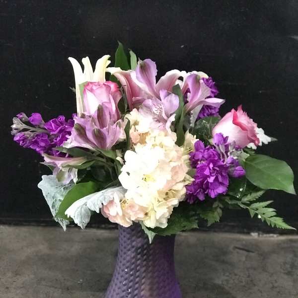 Purple and pink mixed bouquet in a textured purple vase