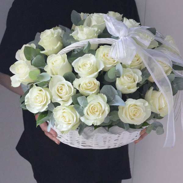 Basket of white roses with eucalyptus and a white ribbon bow