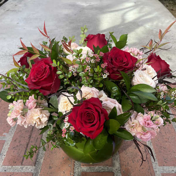 Bouquet of red and pale pink roses in a low vase