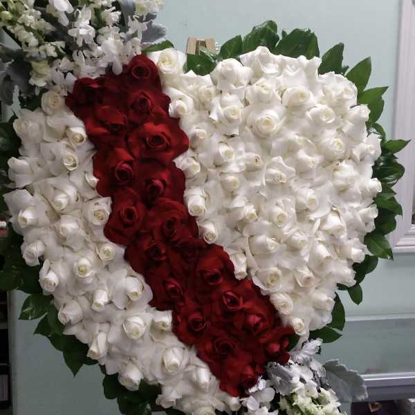 Heart-shaped rose arrangement with red and white roses on an easel