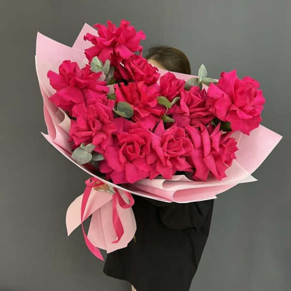 Large bouquet of bright pink flowers wrapped in pale pink paper