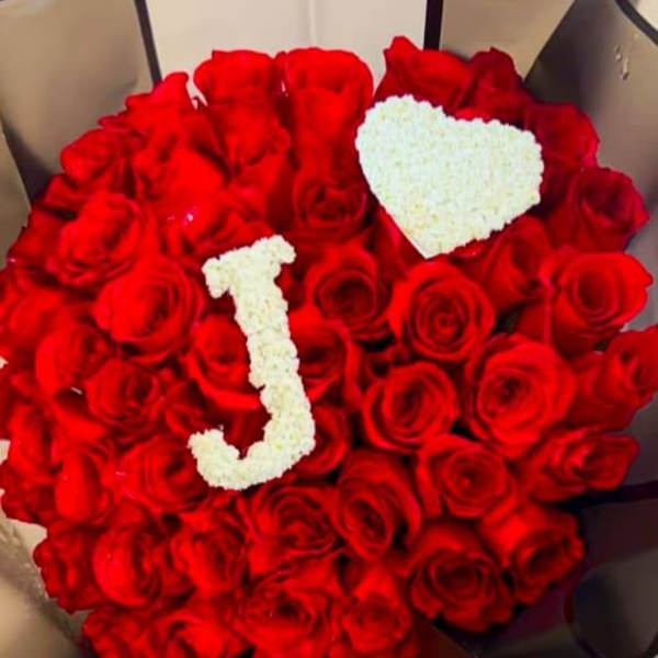 Heart-shaped bouquet of red roses with white floral letters