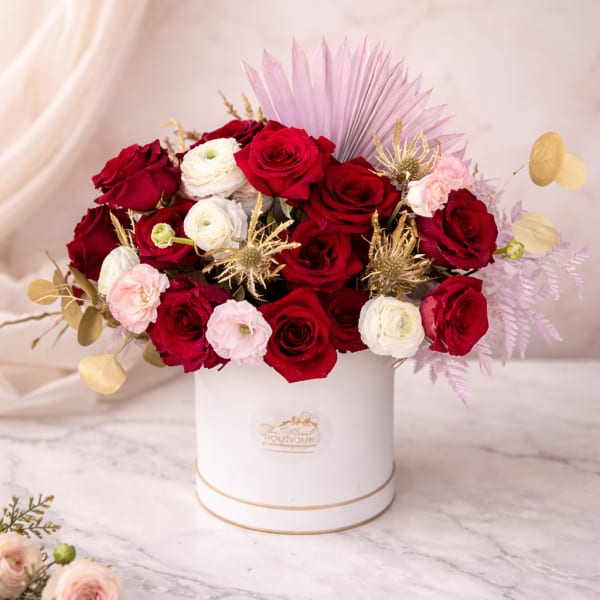 Red and white roses arranged in a white hat box
