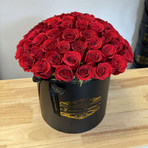 Large bouquet of red roses in a black round box