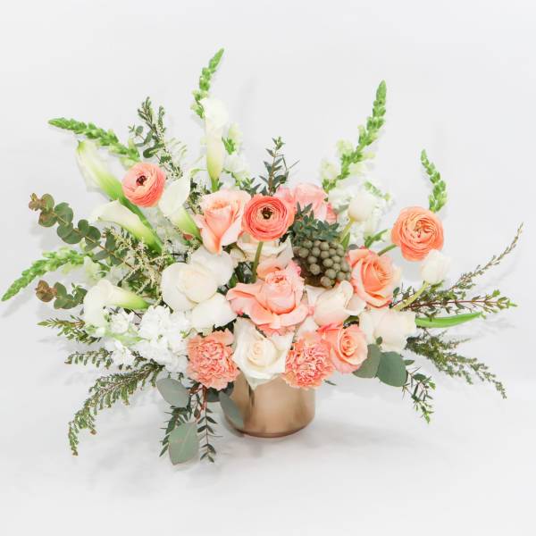 Peach and white bouquet in a gold vase