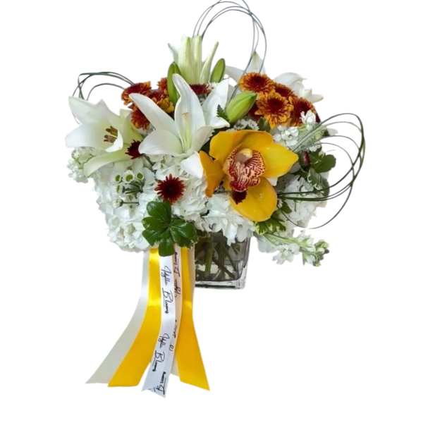 White lilies and yellow orchids in a glass vase with ribbon streamers