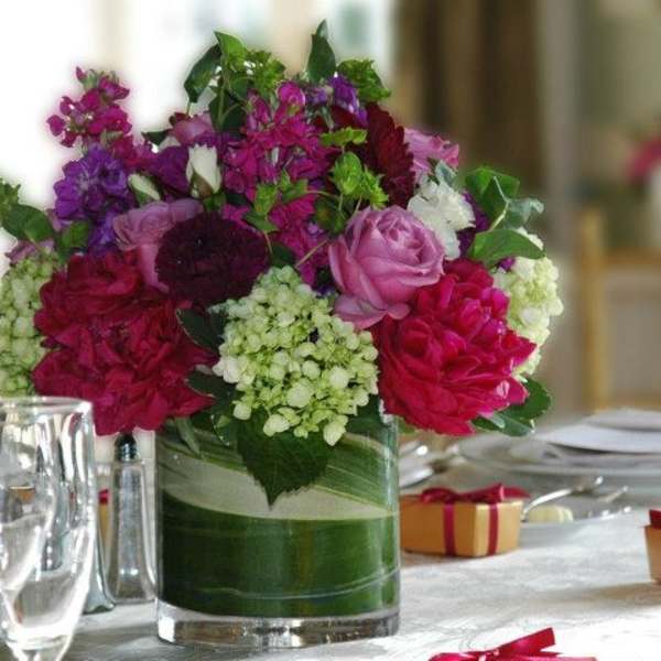 Mixed pink and purple flower arrangement in a glass vase