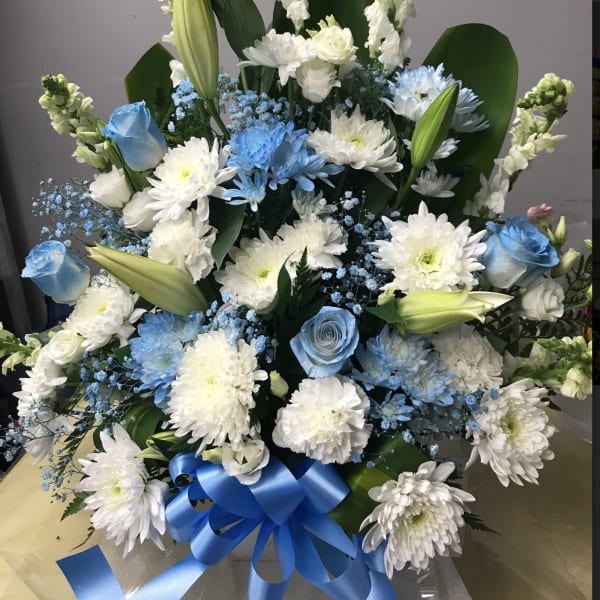 Large bouquet of white and blue flowers with a blue ribbon