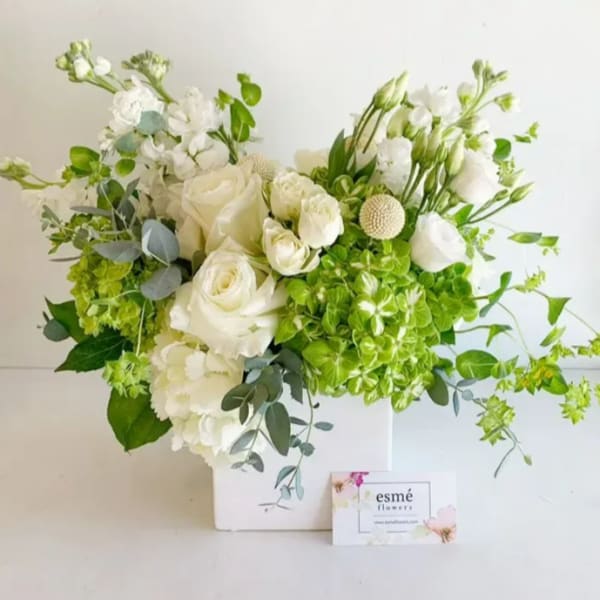White roses and green hydrangeas in a white box arrangement