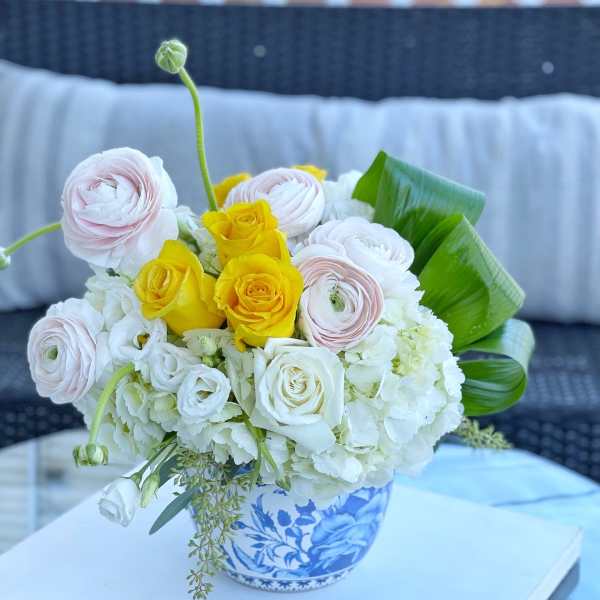 Bouquet of white, pink, and yellow flowers in a blue-and-white vase