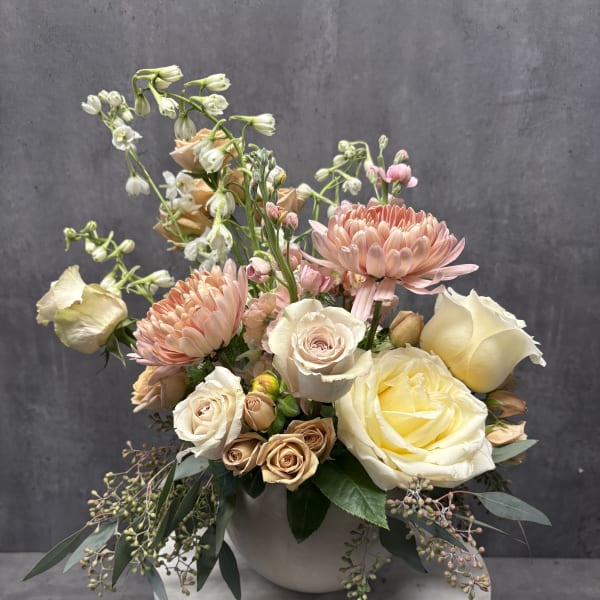 Pastel bouquet of roses and chrysanthemums in a white vase