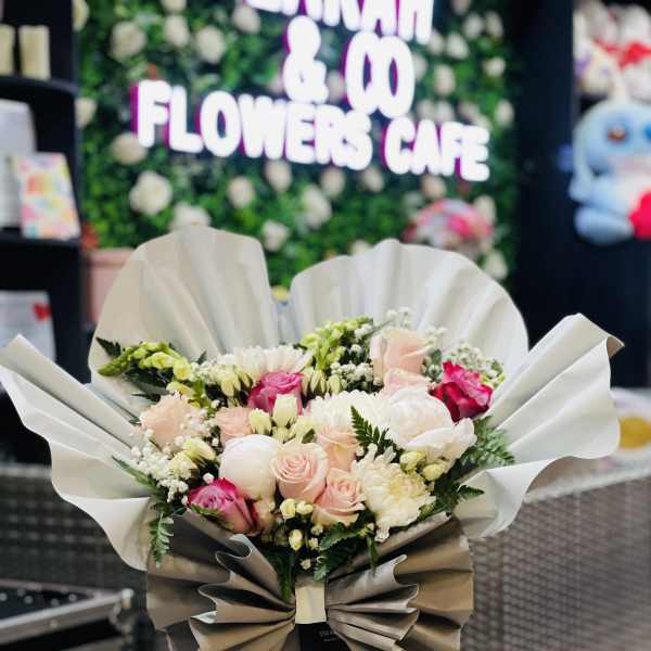 Bouquet of pink and white roses wrapped in white and beige paper