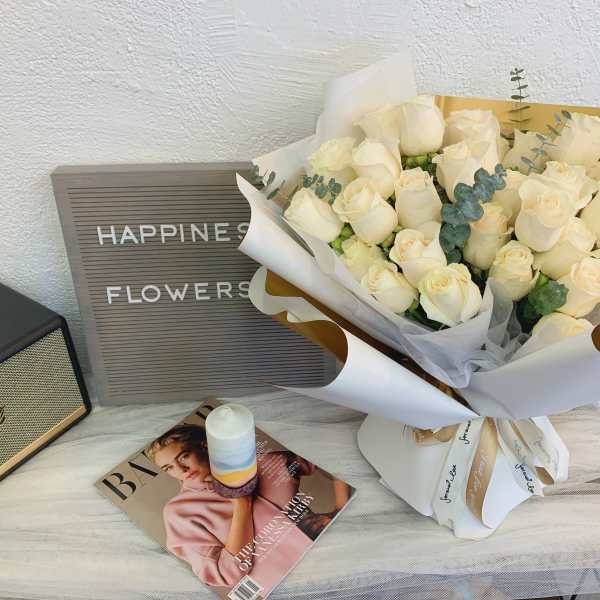 Bouquet of cream roses wrapped in white paper