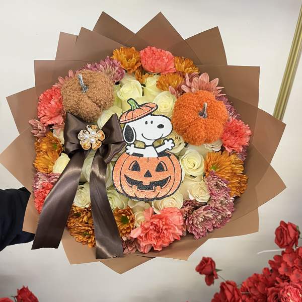Halloween bouquet with roses, carnations, and pumpkin decorations