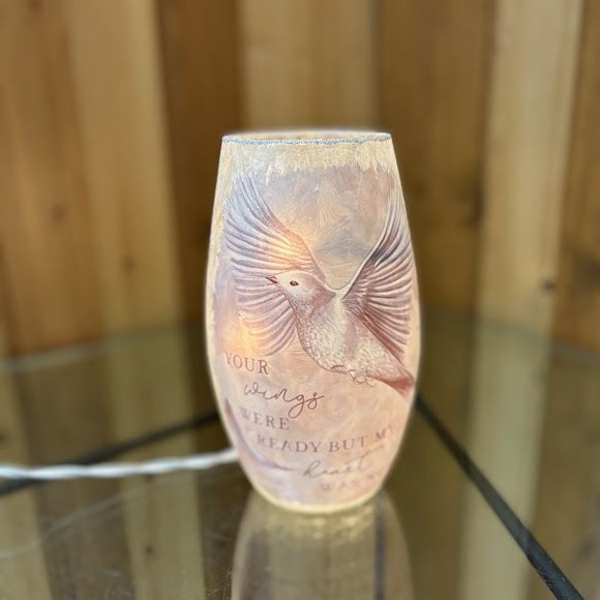 Decorative glass candle holder with a bird design and printed text