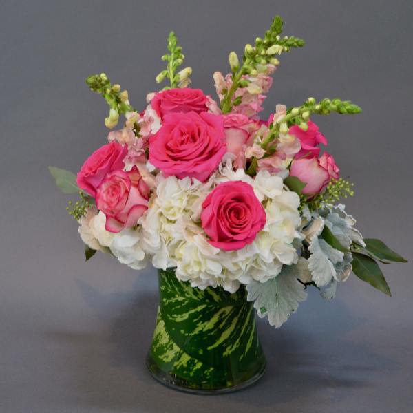 Pink roses and white hydrangeas in a green glass vase