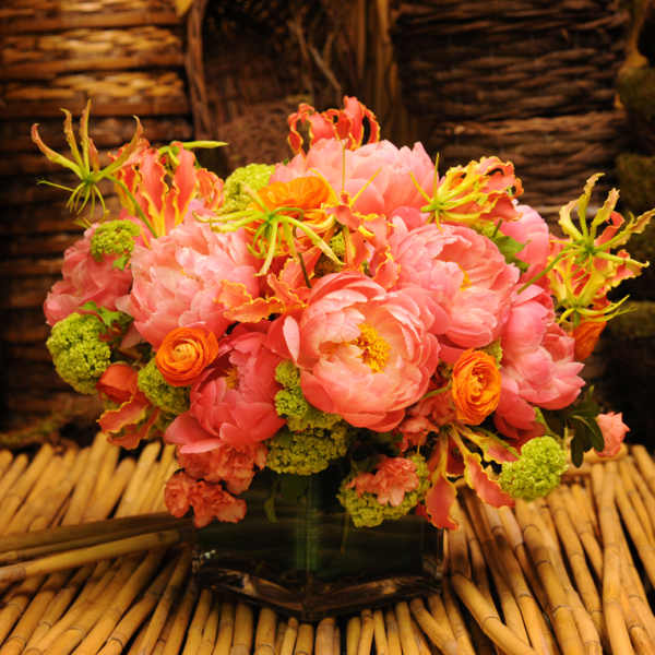 Pink and orange floral arrangement in a glass vase