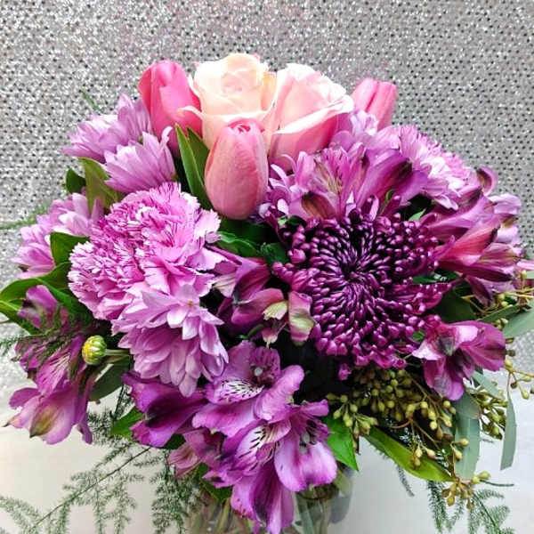 Pink and purple bouquet in a clear glass vase
