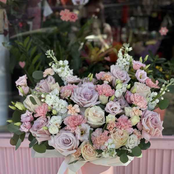 Pastel pink and lavender bouquet in a pink hat box with ribbon.