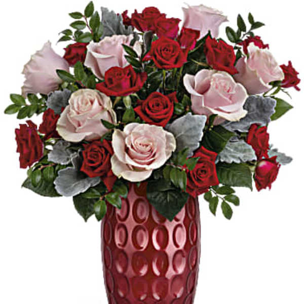 Red and pale pink roses arranged in a tall red vase