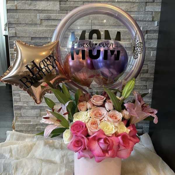 Pink and peach roses in a round box with birthday balloons