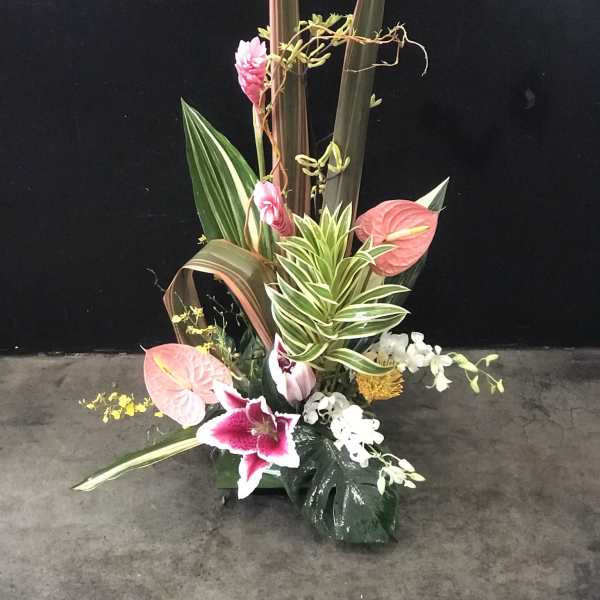 Tall tropical floral arrangement with pink anthuriums and orchids